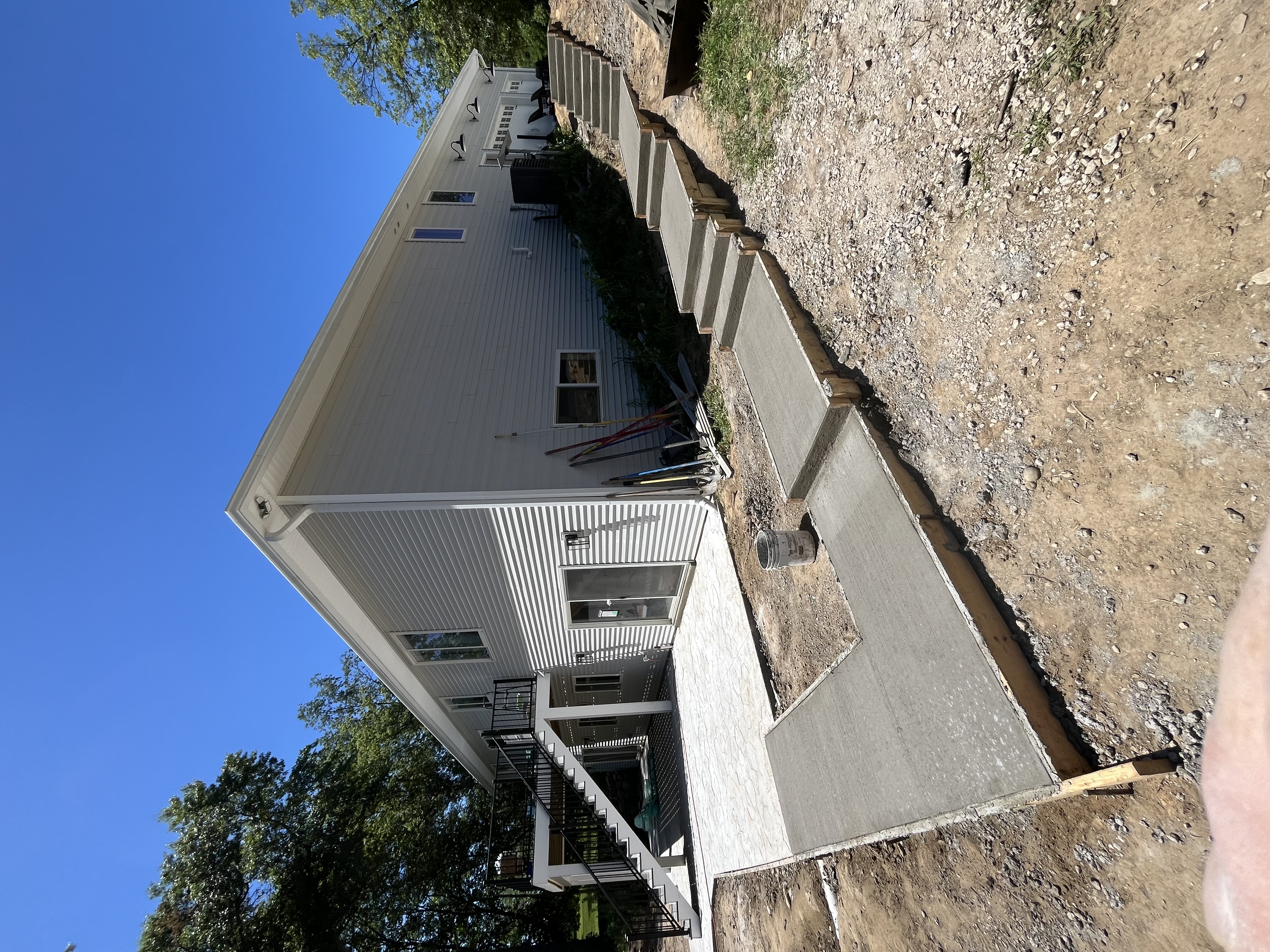 Concrete patio and foundation work alongside house