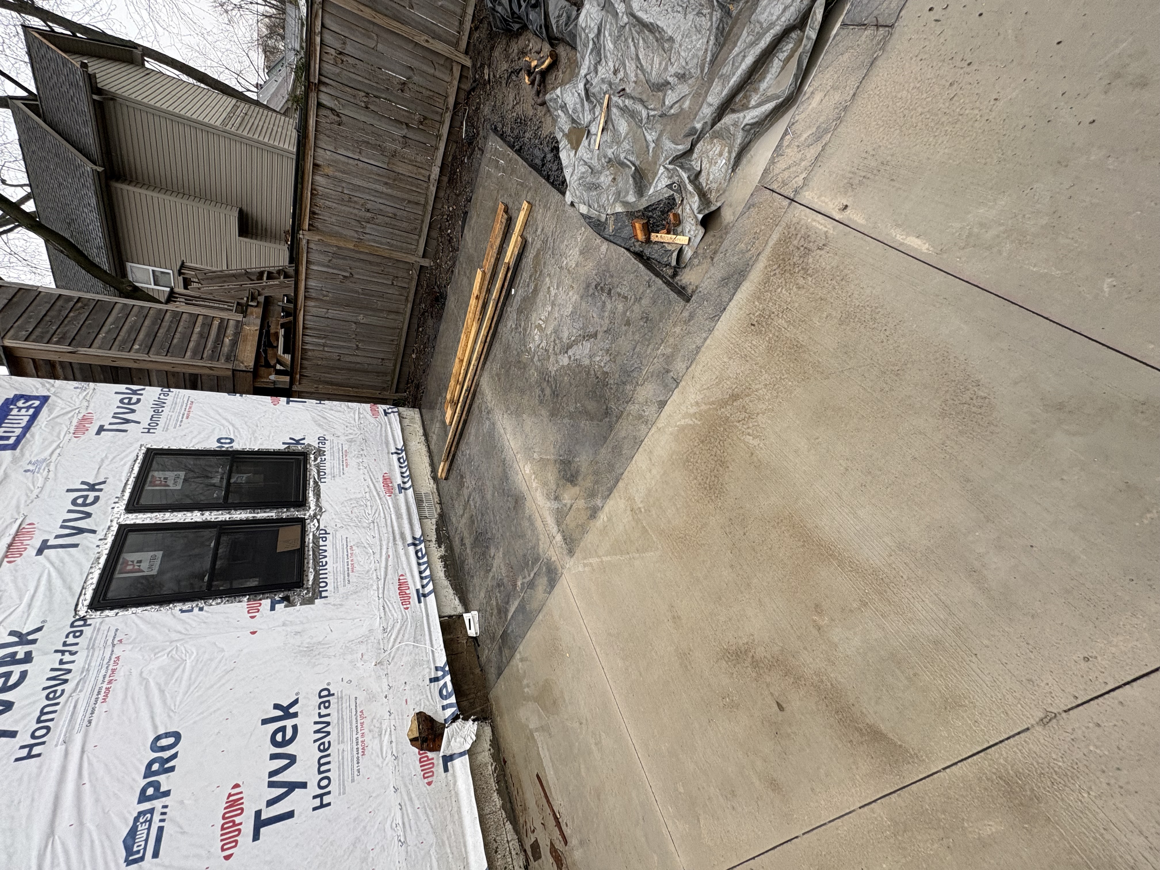 Concrete driveway and slab alongside new construction
