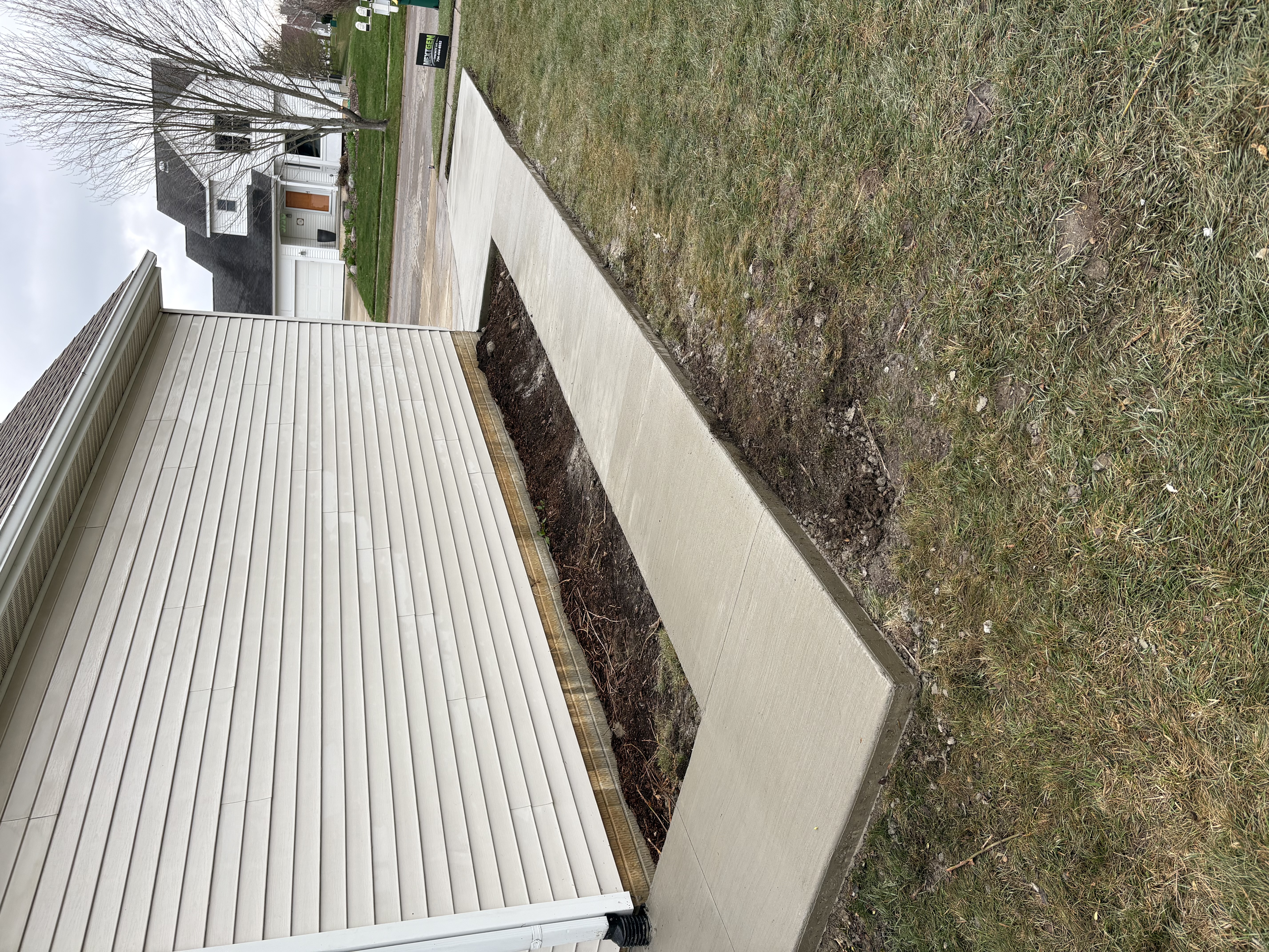 Concrete driveway side view with clean edge along lawn