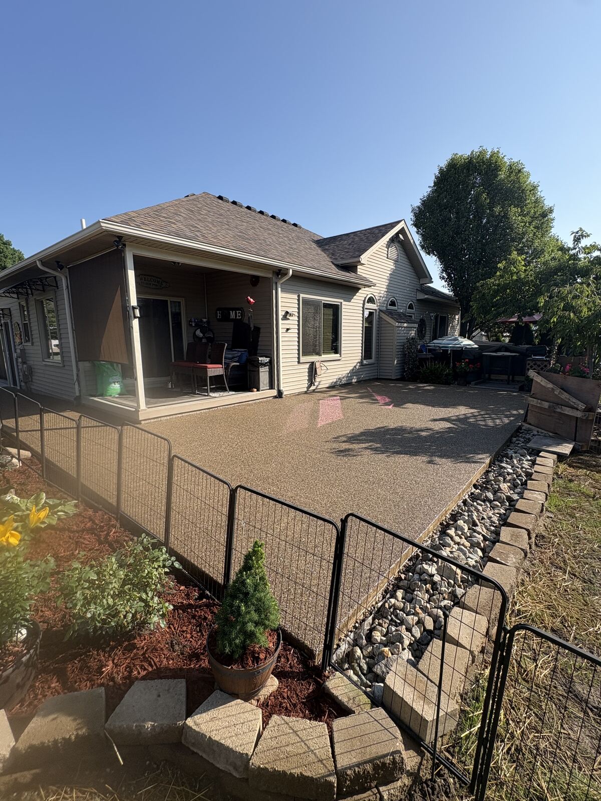 Exposed aggregate backyard patio under covered porch