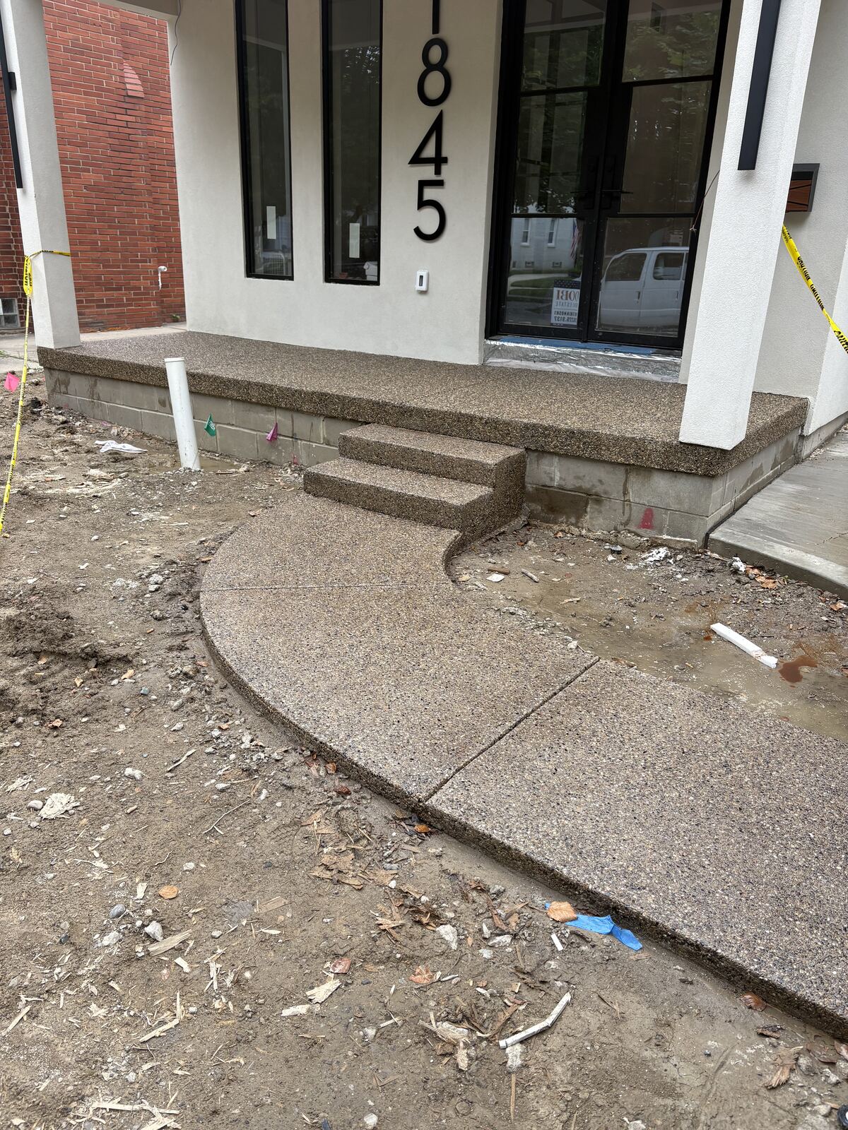 Exposed aggregate front porch, steps, and curved walkway at new home
