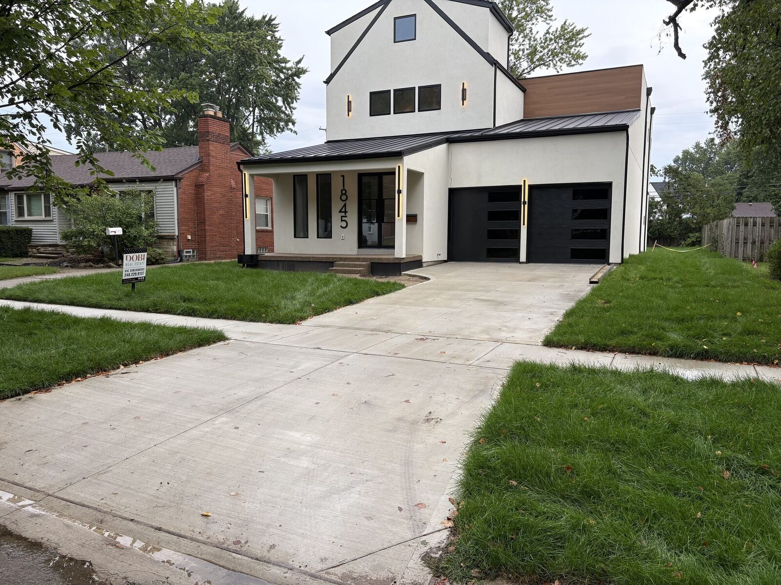 Finished concrete driveway, approach, and sidewalk at a modern new home