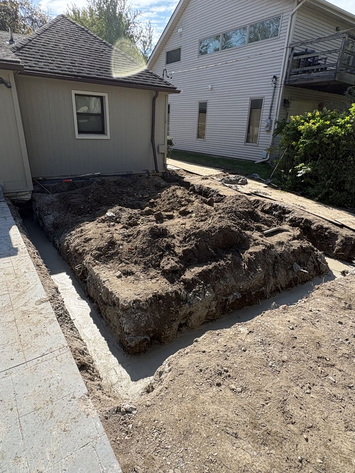 Poured concrete footings around excavated foundation addition next to house